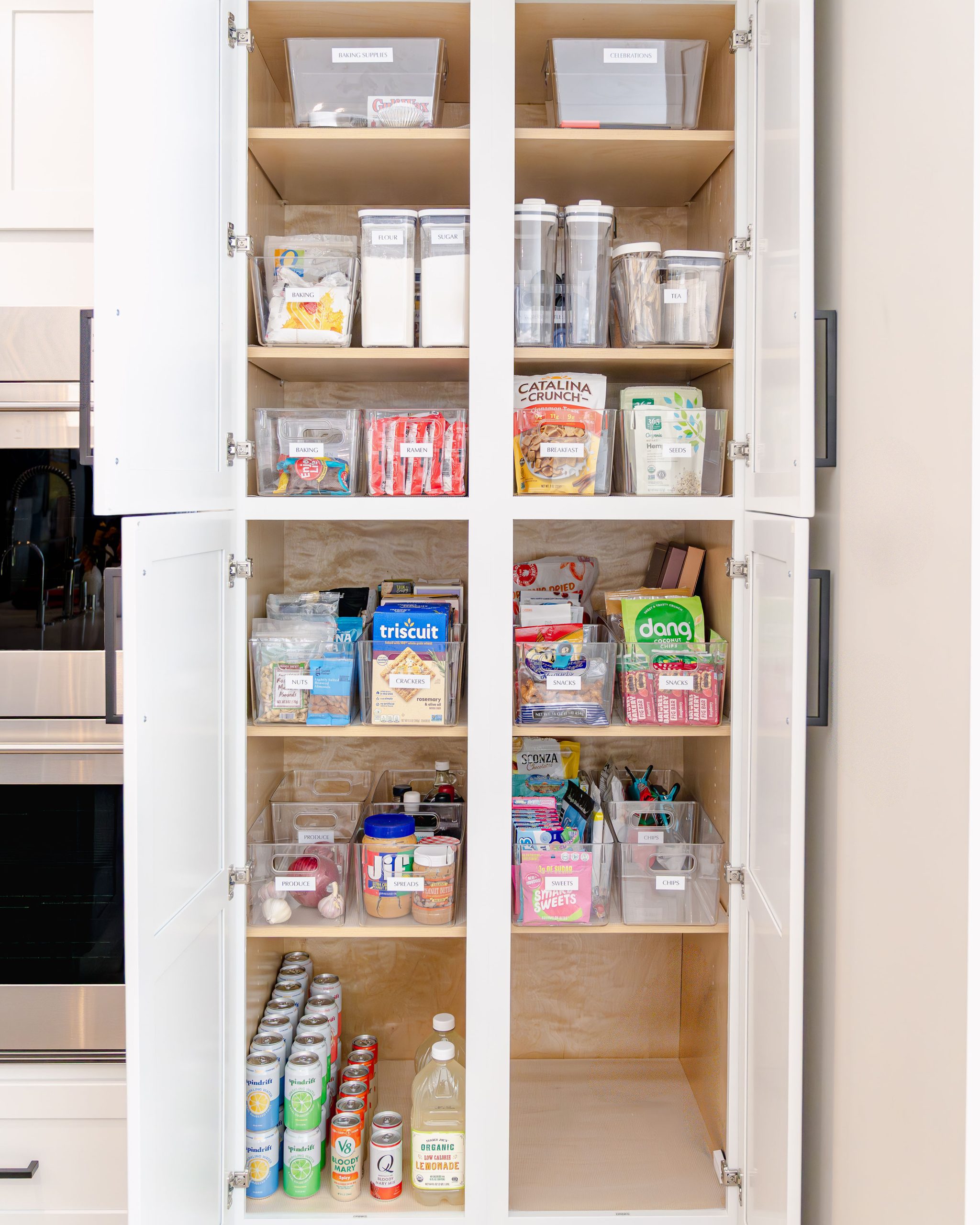 A pantry professionally organized by Sorted Spaces with labeled clear bins and neatly arranged food